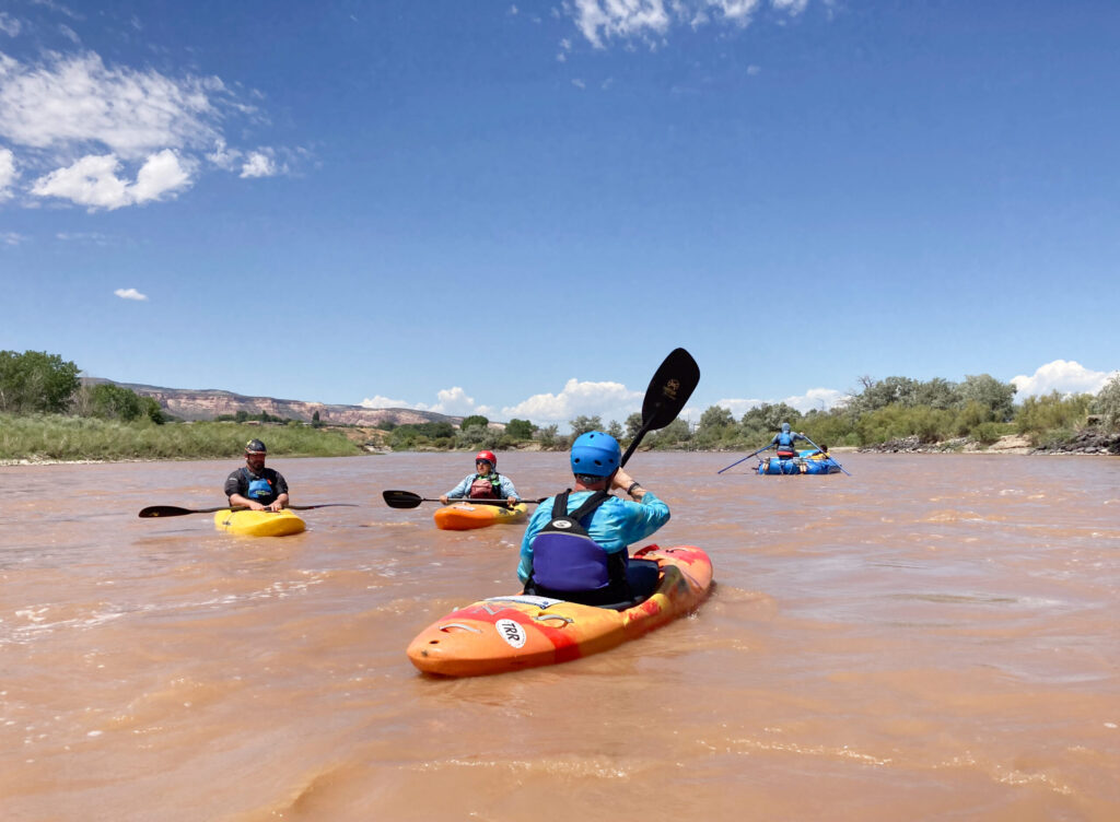 CDA Kayakers gather on a river during a group paddling activity