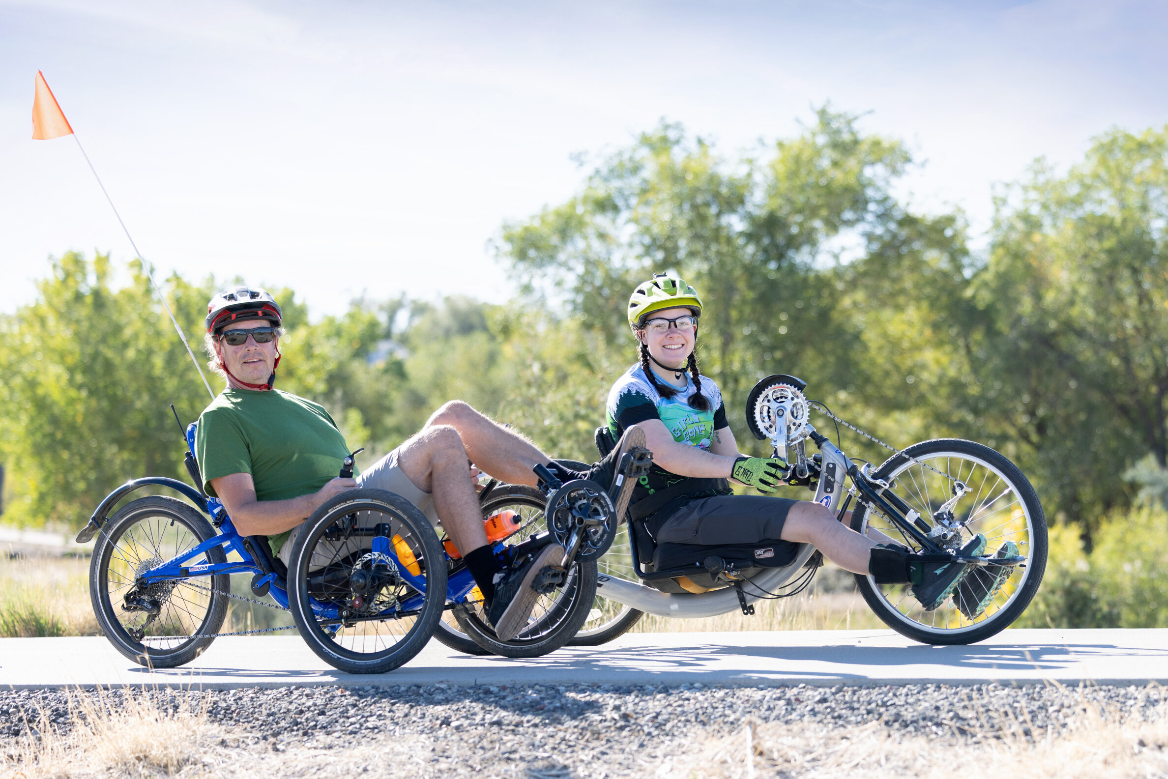 A CDA volunteer and participant riding recumbent tricycles along the Riverfront Trail.