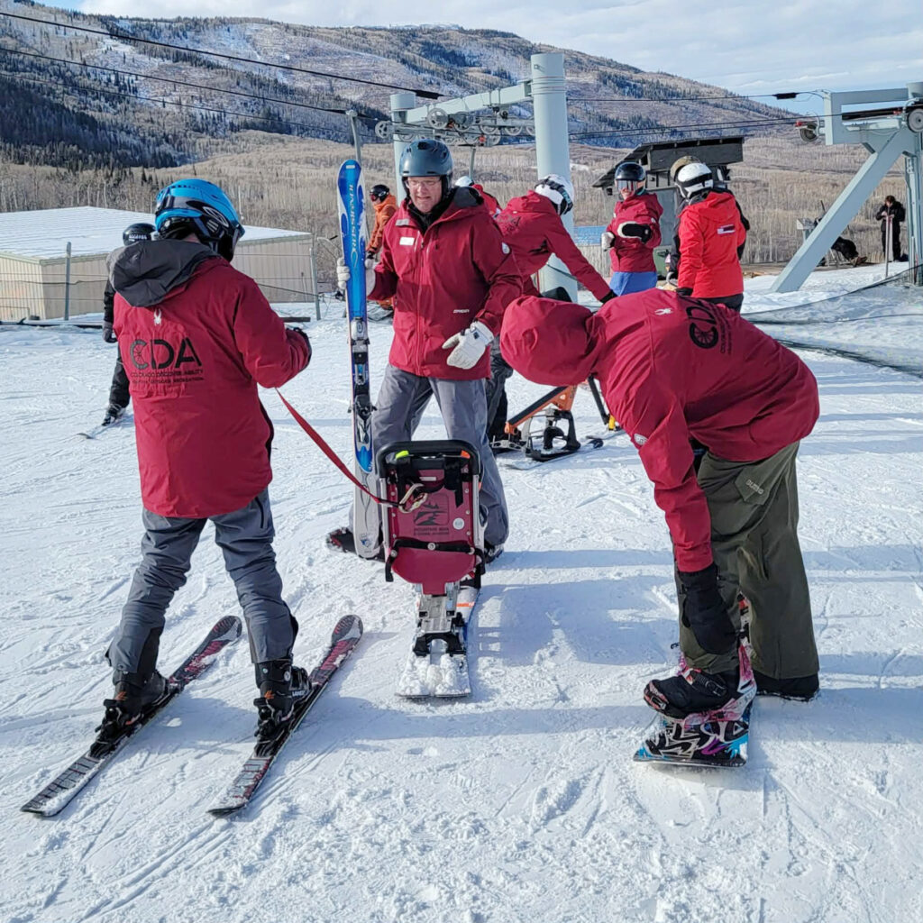 CDA volunteers at an adaptive ski clinic in Powderhorn practicing with a sit ski.