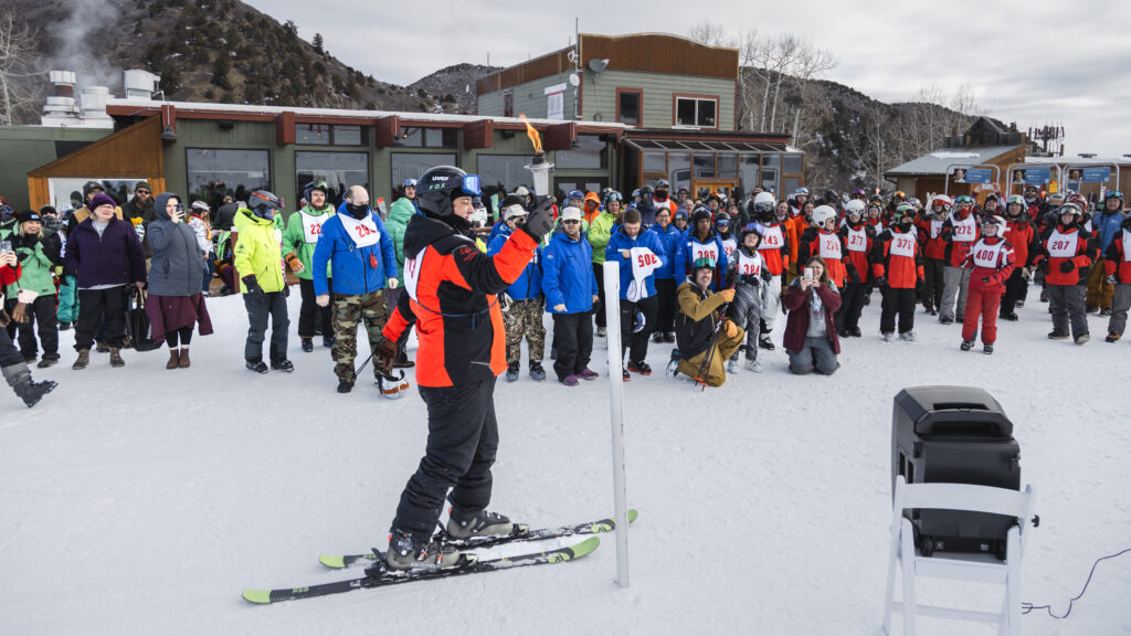 Team Powderhorn participant lighting the torch to signal the start of the Special Olympics Winter Games