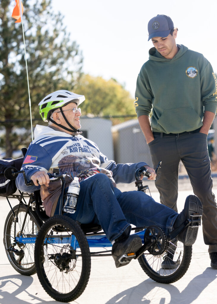 CDA program manager talking to a CDA participant on a recumbent tricycle.